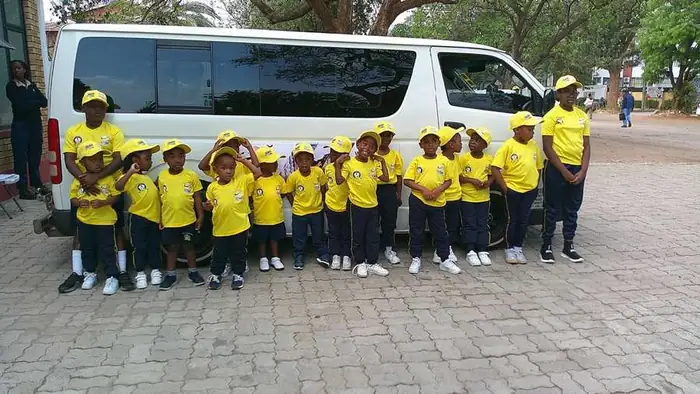 Learners with the school transport van